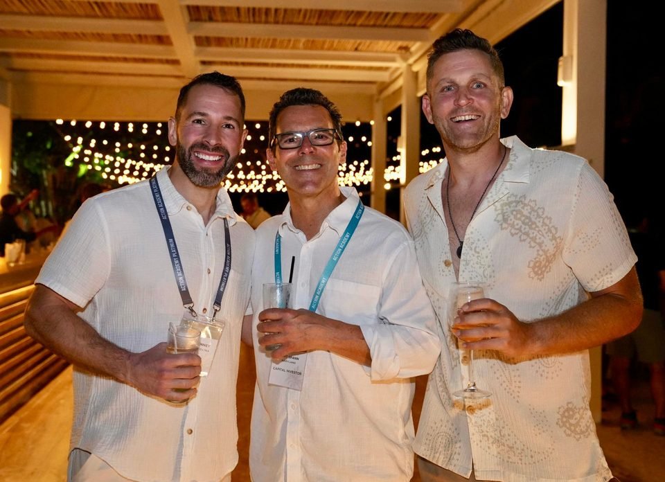 Tyler Denney, Kurt Spann, and Chris Monsour smiling together at an evening gathering in the Dominican Republic.